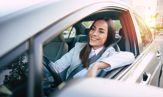 Portrait de jolie femme pilote de voiture avec ceinture de sécurité