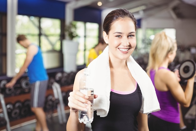 Portrait, de, jolie femme souriante, à, bouteille eau, à, gymnase