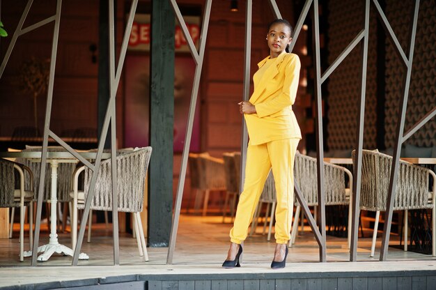 Portrait d'une jolie fille afro-américaine gaie et gaie à la mode et attrayante qui porte une veste ou un costume de couleur jaune vif et brillant.