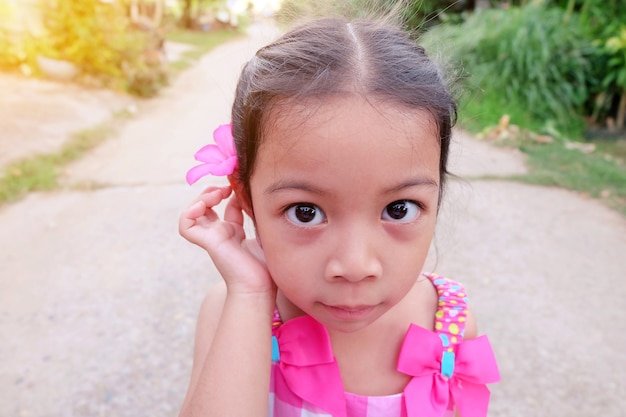 Portrait d&#39;une jolie fille d&#39;âge préscolaire avec fleur sur l&#39;oreille