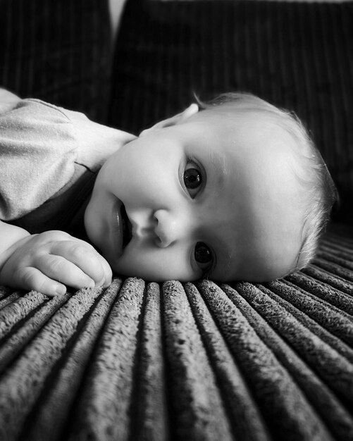 Photo portrait d'une jolie fille allongée sur le canapé à la maison