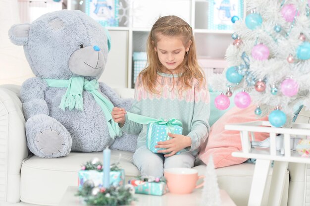 Portrait de jolie fille assise à table avec cadeau