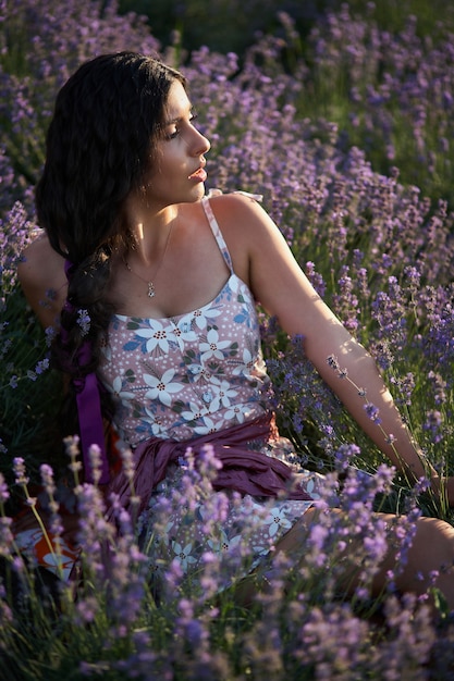 Portrait de jolie fille brune dans le champ de lavande. Modèle de lavande d'été posant devant la caméra.