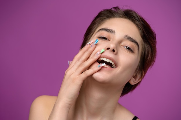 Portrait de jolie fille avec coupe courte et nail art extravagant