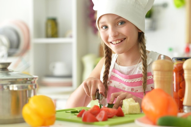 Portrait de jolie fille cuisiner dans la cuisine et écouter de la musique