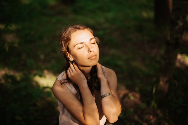 Portrait d'une jolie fille dans un beau parc au coucher du soleil