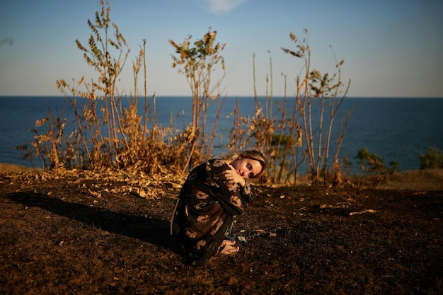 portrait de jolie fille dans la nature Une fille marche à travers le champ sur fond de mer