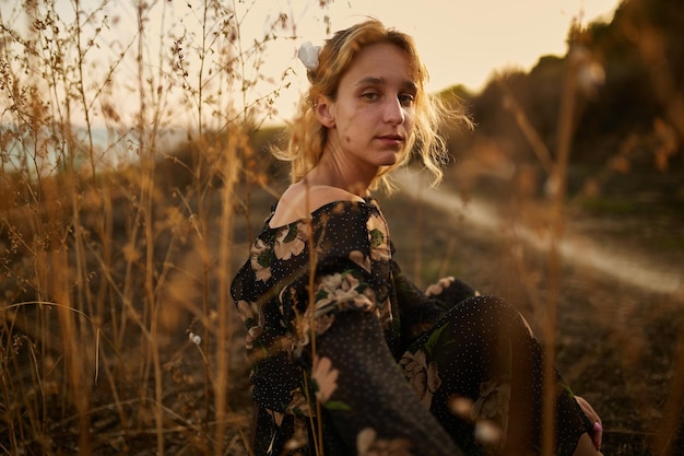 portrait de jolie fille dans la nature Une fille marche à travers le champ sur fond de mer