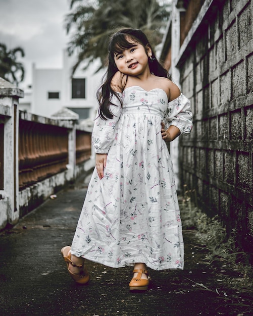 Photo portrait d'une jolie fille debout sur le trottoir