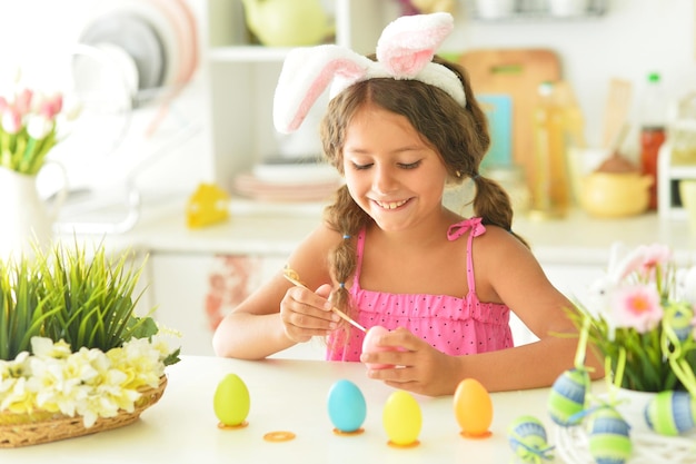 Portrait de jolie fille décorant des oeufs pour les vacances de Pâques