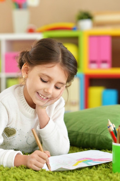 Portrait d'une jolie fille dessinant à la maison