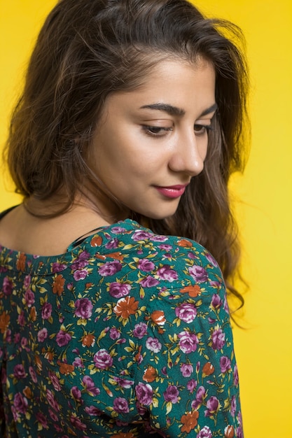 Portrait d&#39;une jolie fille indienne. Jeune femme souriante sur un fond jaune.