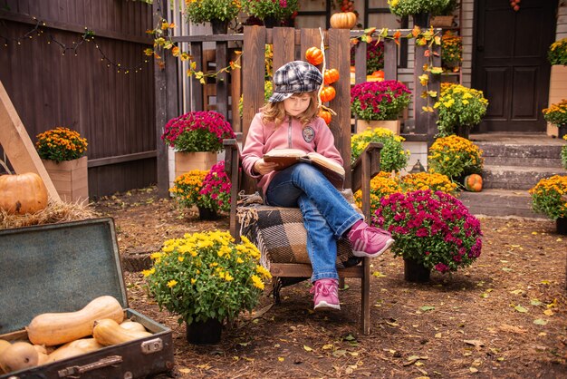 portrait d'une jolie fille avec un livre en automne près de la maison