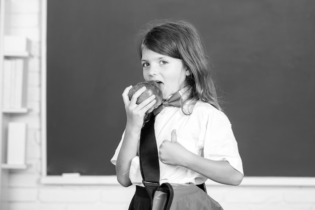 Portrait d'une jolie fille avec une pomme rouge en classe Journée de la connaissance de l'enfant Genius
