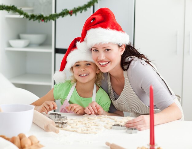 Portrait d&#39;une jolie fille avec sa mère, préparez des biscuits de Noël