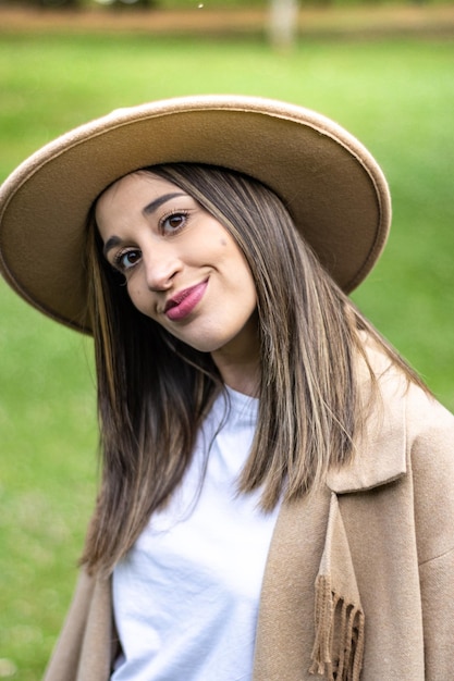 Portrait d'une jolie fille souriante au chapeau à l'extérieur Gros plan d'une jeune femme au chapeau souriant à la caméra sur l'herbe