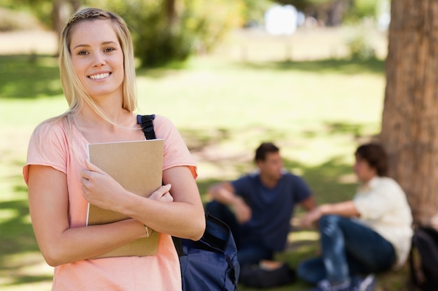 Portrait d&#39;une jolie fille souriante tout en tenant un manuel