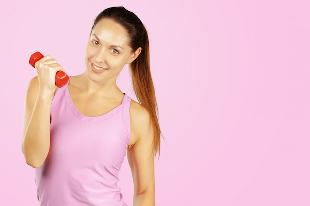 Portrait de jolie fille sportive sur rose