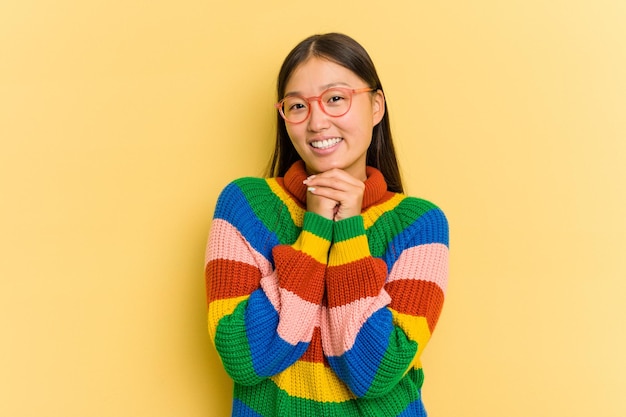 Portrait de jolie jeune femme asiatique isolée sur fond jaune