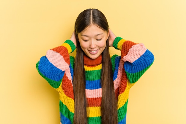 Portrait de jolie jeune femme asiatique isolée sur fond jaune