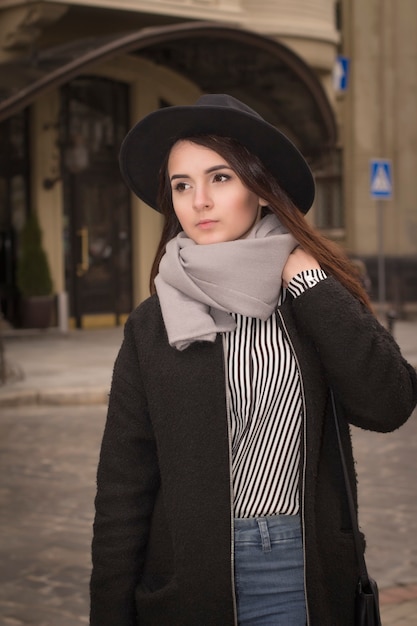 Portrait de jolie jeune femme au chapeau dans la rue