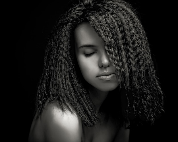 Portrait de jolie jeune femme aux cheveux bouclés