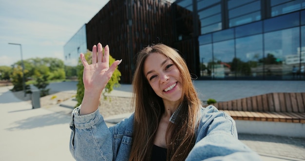 Portrait jolie jeune femme ayant un chat vidéo parler souriant à la lumière du soleil sur la rue Selfie happy chat appel téléphonique