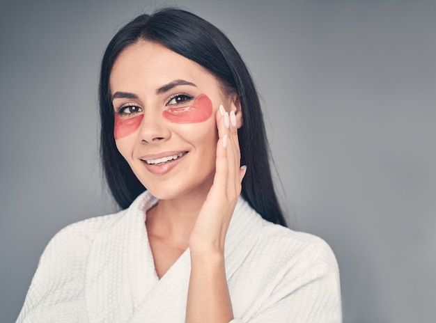 Portrait d'une jolie jeune femme caucasienne heureuse avec des coussinets de gel souriant à l'avant