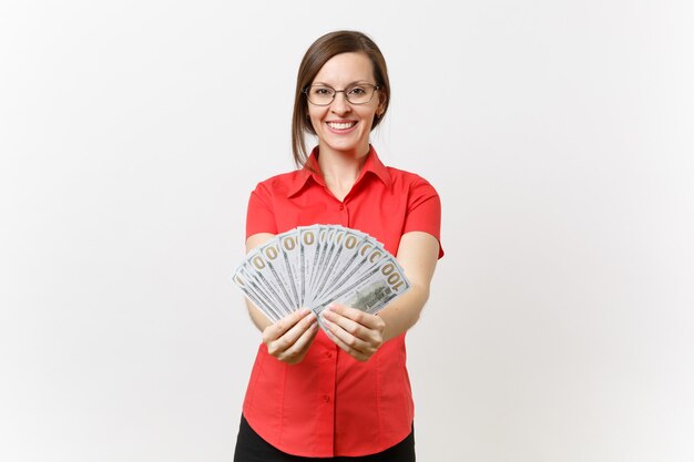 Portrait d'une jolie jeune femme enseignante d'affaires dans des lunettes jupe chemise rouge tenant beaucoup de dollars, argent comptant isolé sur fond blanc. Enseignement de l'éducation dans le concept d'université de lycée