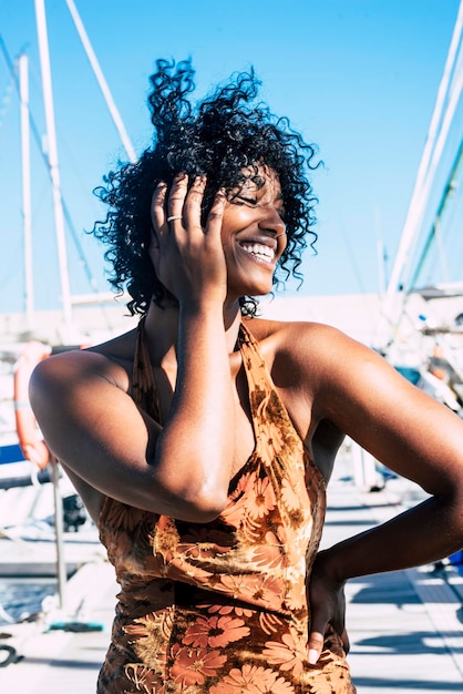 Portrait d'une jolie jeune femme noire avec une robe d'été s'amuser et rire beaucoup seule