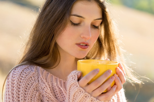 Portrait de jolie jeune femme en pull tricoté élégant debout sur la forêt d'automne dorée