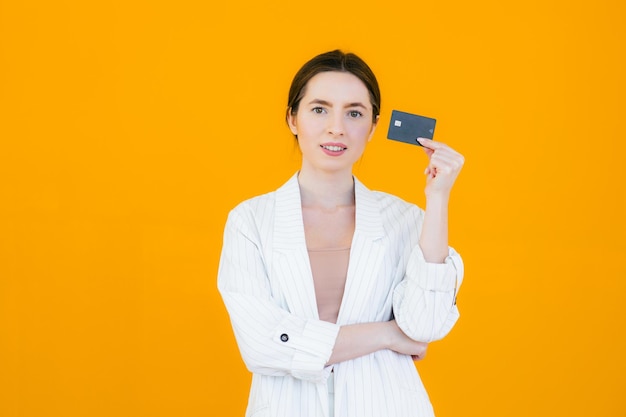 Portrait d'une jolie jeune femme tenant une carte de crédit sur son visage