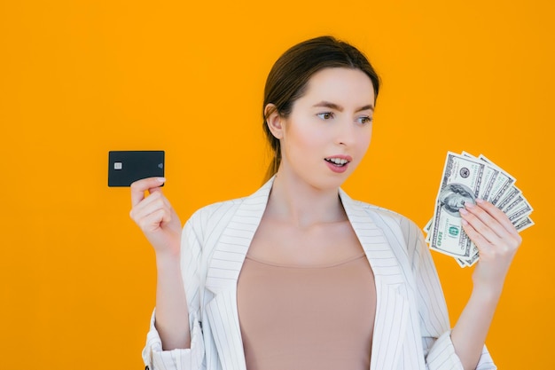 Portrait d'une jolie jeune femme tenant une carte de crédit sur son visage