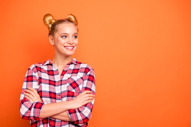 Portrait de jolie jeune femme vêtue d'une chemise à carreaux à carreaux isolée sur orange