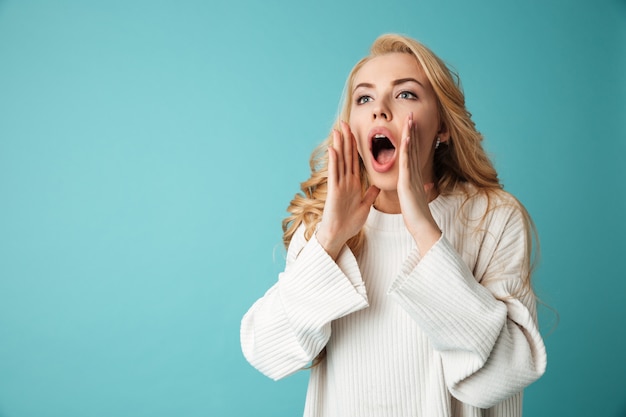 Portrait d'une jolie jeune fille blonde appelant à quelqu'un