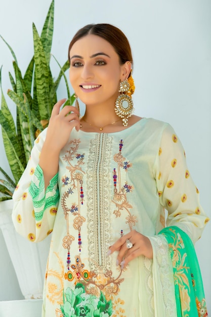 Portrait de jolie jeune fille souriante portant une robe Desi et des bijoux pour une séance photo de mode