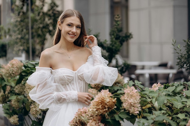 Portrait de jolie jeune mariée en robe de mariée fleur d'hortensia avec décolleté