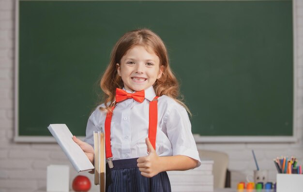 Portrait de jolie jolie fille en uniforme scolaire en classe