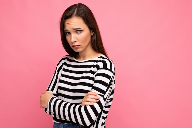 Portrait de jolie jolie jeune femme brune triste et bouleversée portant un pull rayé décontracté