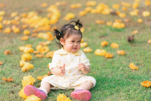 Portrait de jolie petite fille asiatique dans le jardin de fleurs