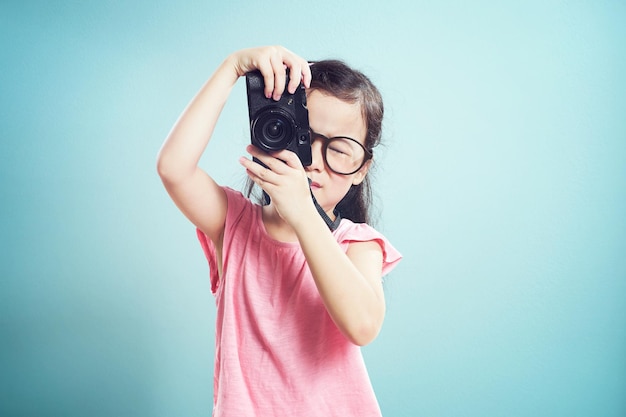 Portrait D'une Jolie Petite Fille Asiatique Prenant Une Photo Avec Un Appareil Photo Rétro En Studio Sur Fond Vert Menthe Vintage