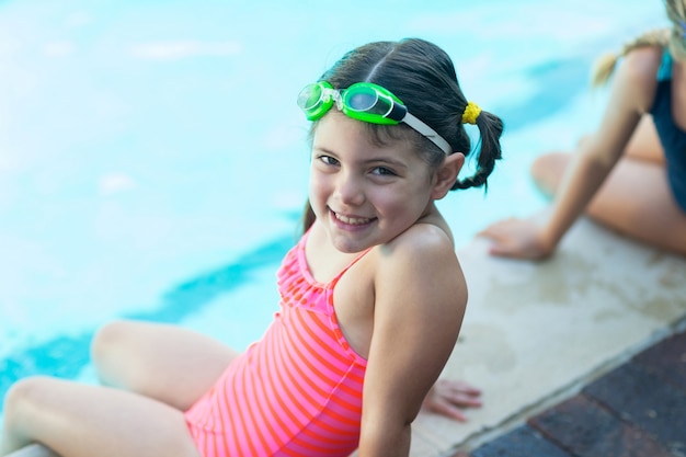 Portrait de jolie petite fille au repos au bord de la piscine