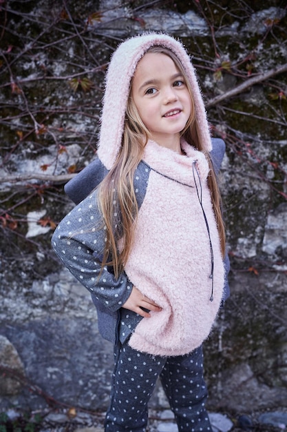 Portrait de jolie petite fille blonde sur fond de roche grise.
