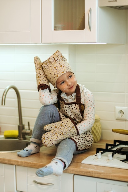 Portrait de jolie petite fille homecook dans la cuisine blanche