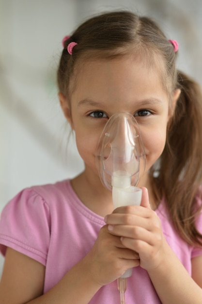 Portrait d'une jolie petite fille avec inhalateur