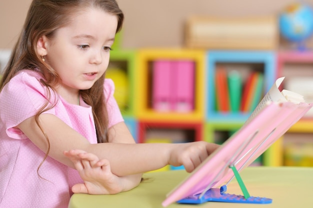 Portrait de jolie petite fille lisant un livre