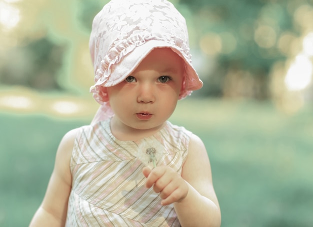 portrait d'une jolie petite fille avec un pissenlit