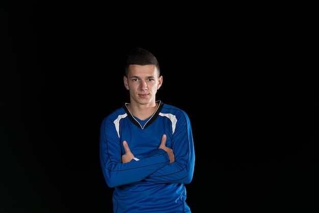 Portrait d'un joueur de football et balle sur le terrain du stade de football isolé sur fond noir