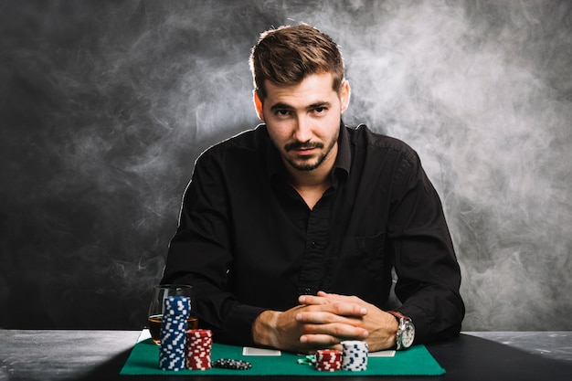 Portrait d'un joueur avec des jetons de casino et des cartes à jouer