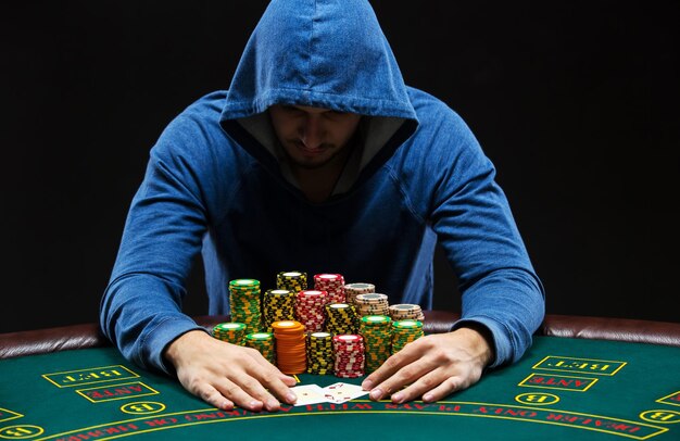 Portrait d'un joueur de poker professionnel assis à une table de poker